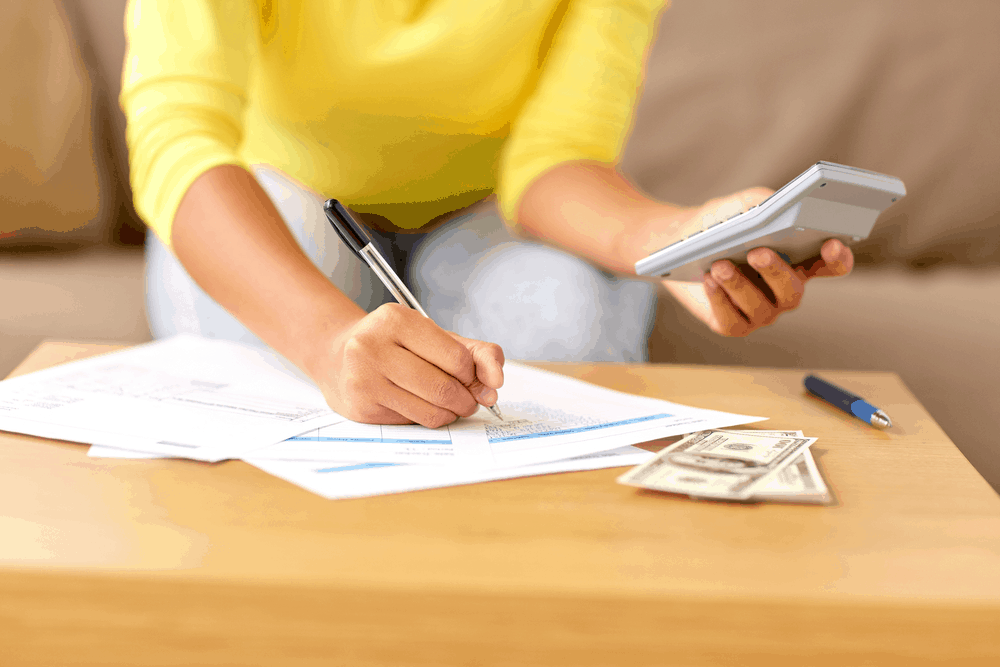 woman with money, papers and calculator at home